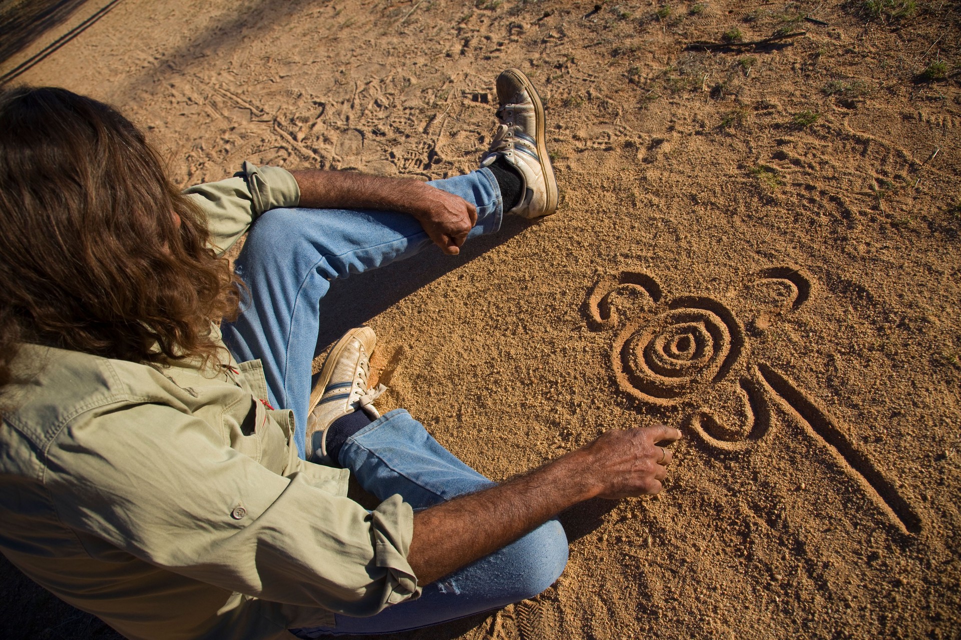 Aboriginal man drawing in the dirt